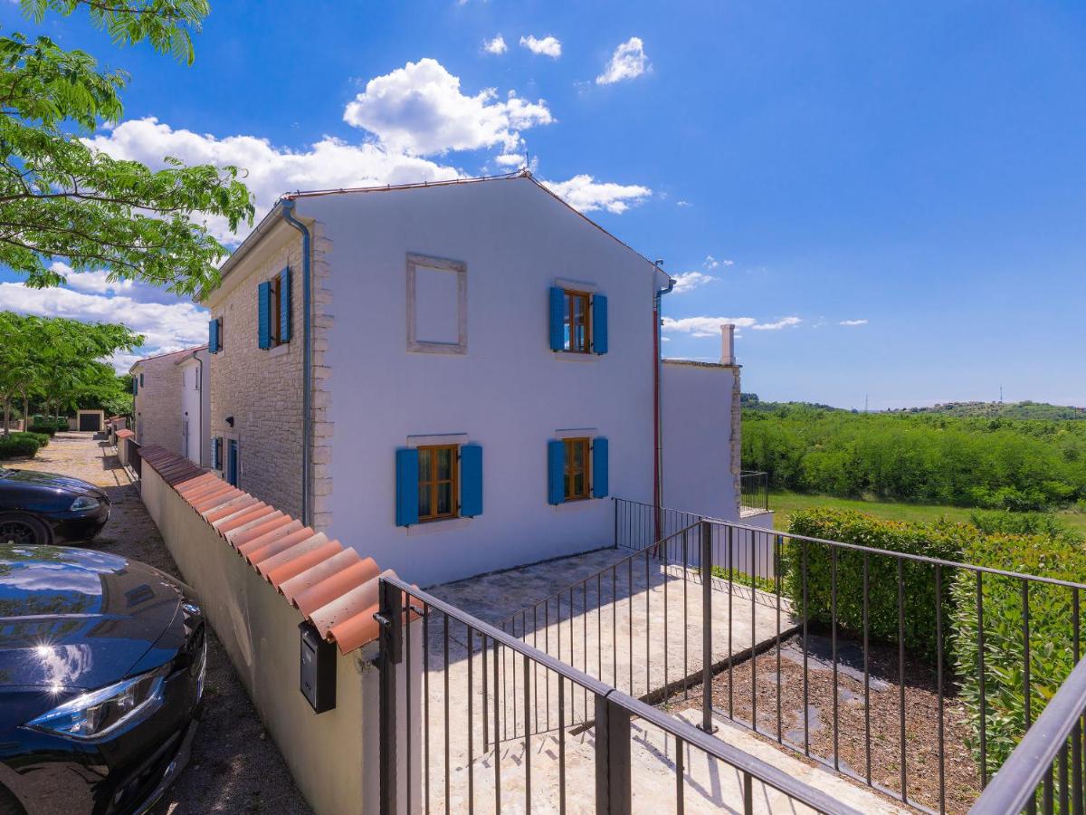 Weißes Steinhaus mit türkisen Fensterläden und Terrasse mit Weitblick